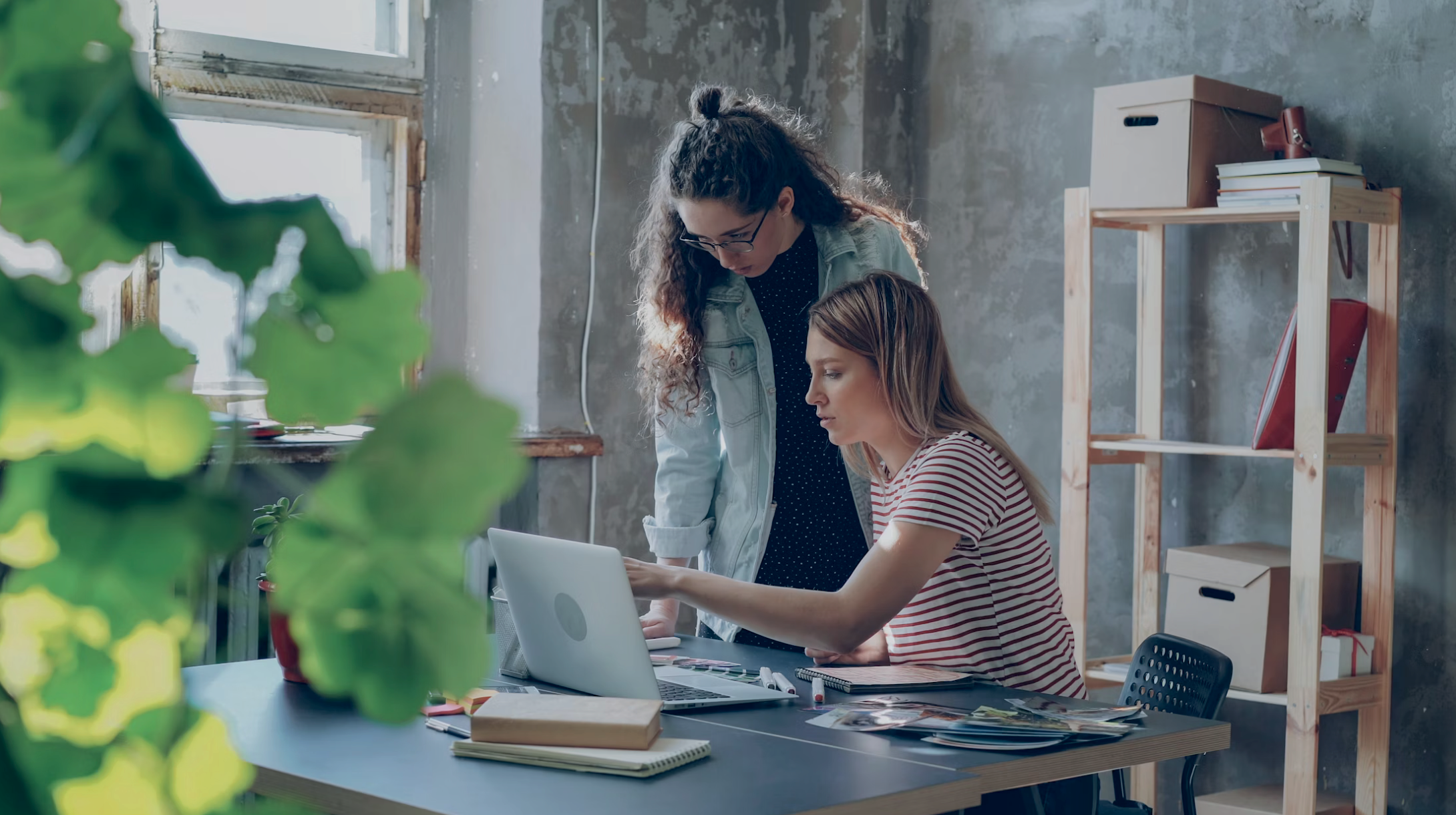 2 women discussing green walls at computer